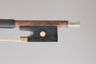 a close up of a violin bow with a piece of wood sticking out of it