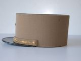beige top hat with gold trim on a plate on a white surface