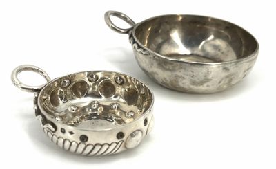pair of silver plated bowls with handles on a white surface