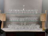 a glass shelf with a lot of glasses on it
