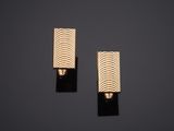 une paire de boucles d'oreilles en or sur fond noir
