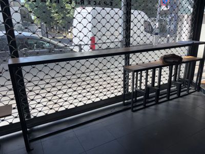 a view of the outside of a coffee shop through a fence