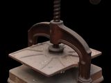 an old cast iron press with a wooden base on a black background
