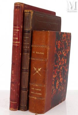 two old books are stacked on top of each other on a table