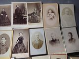 a lot of old photos of men and women on the table