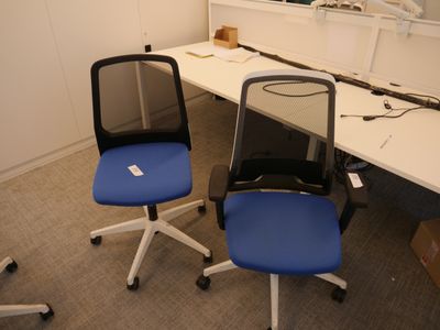 deux chaises de bureau bleues placées devant un bureau blanc