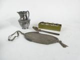 a silver vase, a spoon, and other items on a white surface