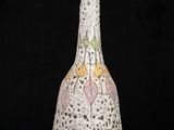 a white vase with a pink and yellow design on it