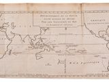 an old map of the world being held up by a hand