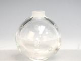 un vase en verre transparent muni d'un couvercle blanc, posé sur une table