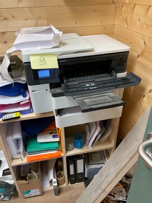 une imprimante posée sur un bureau dans un coin de la pièce