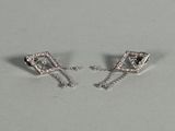pair of white gold and diamond earrings on a white surface