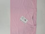 une chemise rose avec une étiquette, posée sur une table