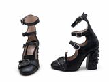 une paire de chaussures noires à talons hauts, ornées de boucles de chaque côté