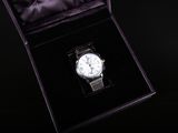 a watch sitting in a black box on a black surface