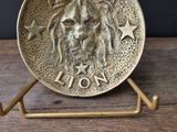 a close up of a metal plate with a lion on it