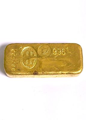 gros plan d'un lingot d'or sur une surface blanche