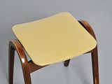 a small wooden stool with a yellow seat on it