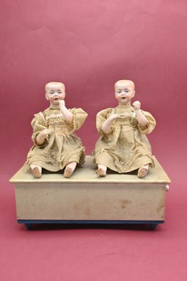 paire de figurines chinoises représentant un garçon et une fille assis sur une boîte