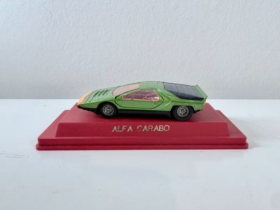 un gros plan d'une petite voiture posée sur un socle rouge
