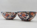 pair of japanese bowls with floral designs on them on a white background