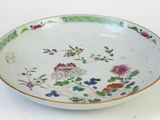 a white bowl with colorful flowers on it on a table