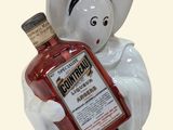 a figurine of a woman holding a bottle of liquor
