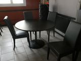 a table and chairs in a room with a window