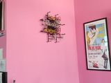 a pink wall in the corner of a restaurant with posters on the wall