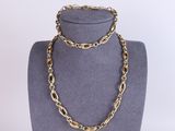 un ensemble composé d'un collier et d'un bracelet en chaîne d'or, présenté sur un mannequin