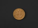 a close up of a gold coin on a black surface