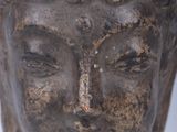 statue of a head of a person with a red ribbon around his neck