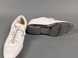 two pairs of white shoes sitting next to each other on a gray surface