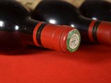 three bottles of wine sitting on a red cloth