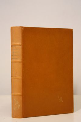 an old book sitting on top of a white table next to a white wall