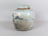 un vase bleu et blanc posé sur une surface blanche