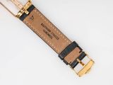 a close up of a black and gold watch strap on a white surface