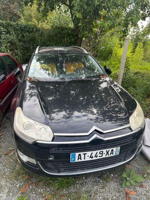 La voiture est garée à côté de la voiture rouge sur le parking.