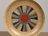 a colorful plate on a stand on a table