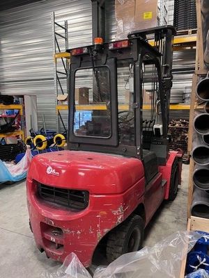 un chariot élévateur rouge garé dans un entrepôt
