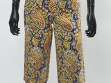 un mannequin vêtu d'une chemise blanche et d'un short à imprimé paisley bleu et jaune
