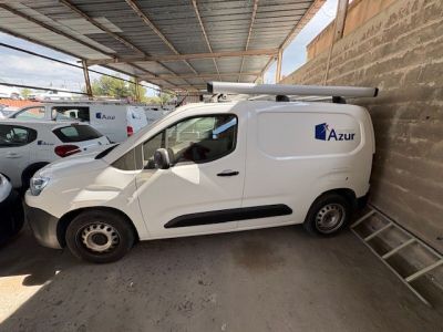 une camionnette blanche garée près d'un mur