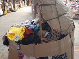 a cardboard cart with clothes on it in a warehouse