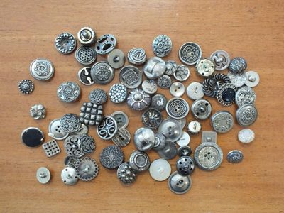 un tas de boutons posés sur une table en bois