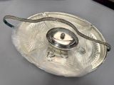 a silver plate with a snake on it on a table