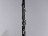 a close up of a saxophone hanging from a string on a wall