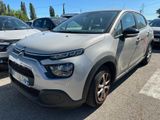 une Citroën argentée garée sur un parking à côté d'autres voitures
