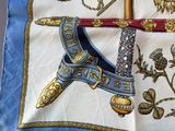 a blue and white scarf with a picture of a sword and a shield on it