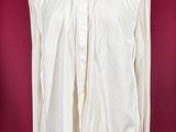 an image of a white shirt on a mannequin stand against a red background