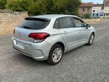 the back of a silver car is parked on the side of the road